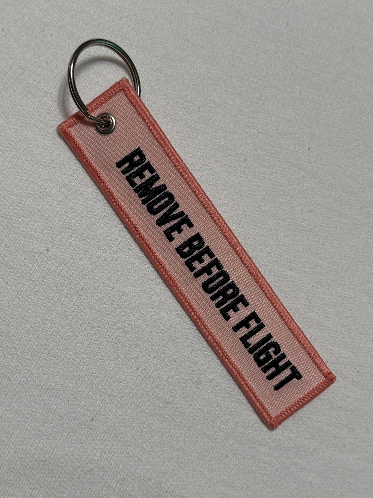 Pink remove before flight keychain