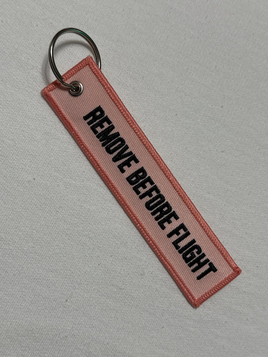 Pink remove before flight keychain